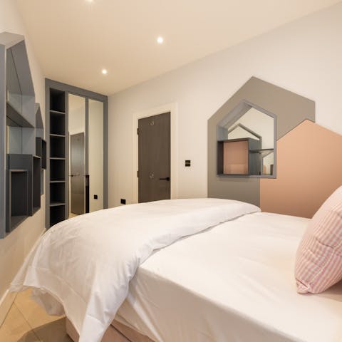 Enjoy a restful night's sleep in the cosy pink-hued master bedroom
