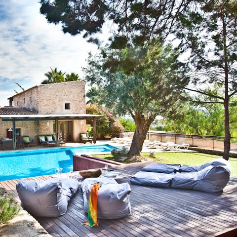 Relax in a bean bag lounger on the deck, shaded by pine trees
