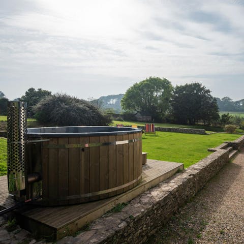 Unwind in the wood-fired hot tub with a glass of bubbly