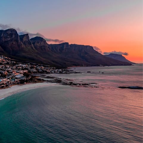 Take a sunset stroll along Camps Bay Beach, a five-minute drive away