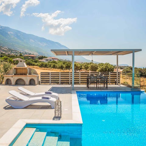 Laze around the pool on the sun loungers
