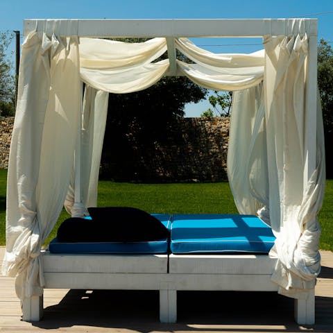 Seek some shade on the linen-draped daybed