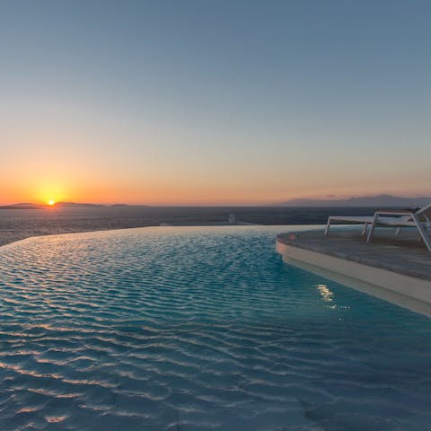 Watch the sun set into the water as you float about in the pool