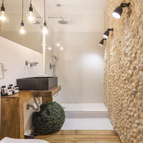 Relax under the rainfall shower in the spa-like stone bathroom