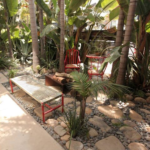 Cosy up round the fire pit in the shared tropical gardens
