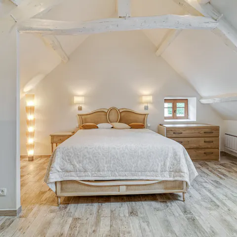 Wake in your tranquil bedroom with exposed, whitewashed beams above you