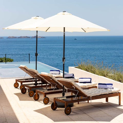 Relax with a cocktail on the sea-facing sun loungers