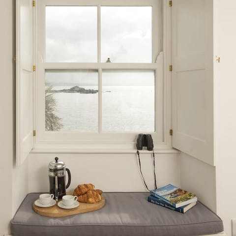 Eat breakfast on the window seat, looking out at the sea 