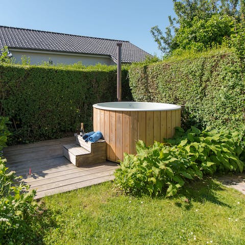 Enjoy a glass of champagne in the hot tub surrounded by verdant hedges