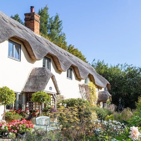 Make your English country dreams come true with a thatched cottage surrounded by pretty gardens