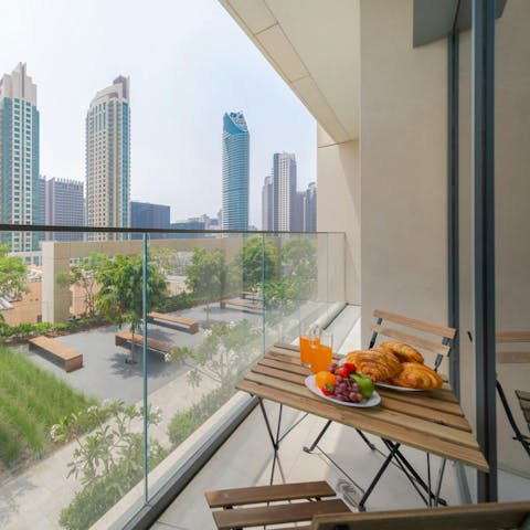 Enjoy breakfast on the balcony overlooking the city's skyscrapers