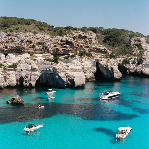 See the boats bobbing from the small beach at Cales Coves, 6.7 km away