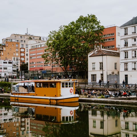Stroll along the Canal Saint-Martin with a coffee in your hand 