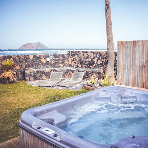 Watch the beauty of nature as the waves crash against the shore from the private hot tub
