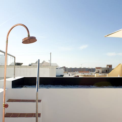 Float in the luxurious private rooftop pool under clear blue skies, and rinse off under the outdoor shower