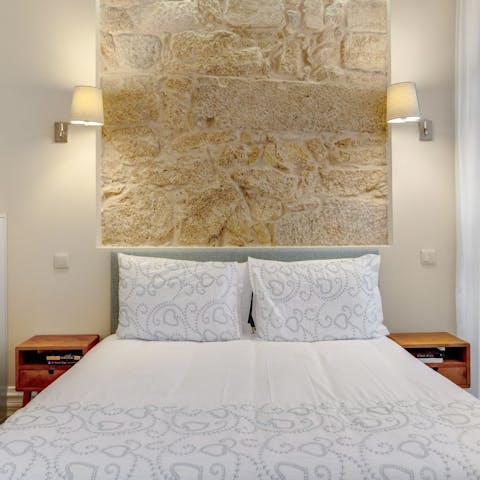 Have some rest in the comfy bed with its exposed stone backdrop