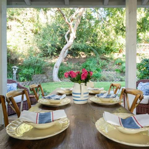 Dine on the shaded porch overlooking the greenery of the garden