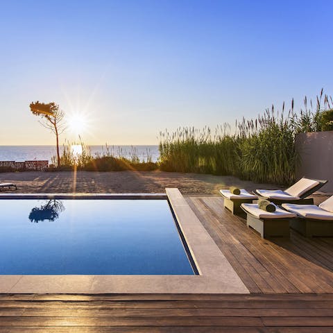 Watch the sun set over the beach from your private pool