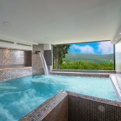 Relax sore muscles beneath the waterfall in the indoor pool
