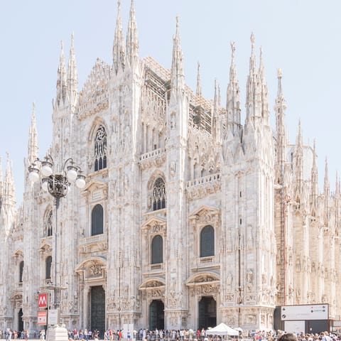 Admire the impressive architecture of the Duomo di Milano – a twelve–minute walk away