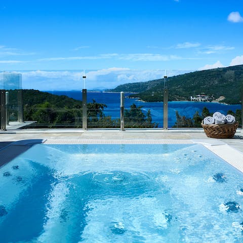 Relax in the hot tub as you drink in the Ionian Sea views