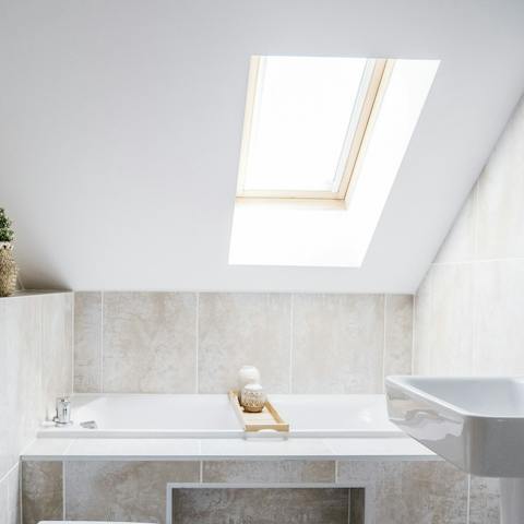 Sit back into steamy water underneath the skylight in the bathtub