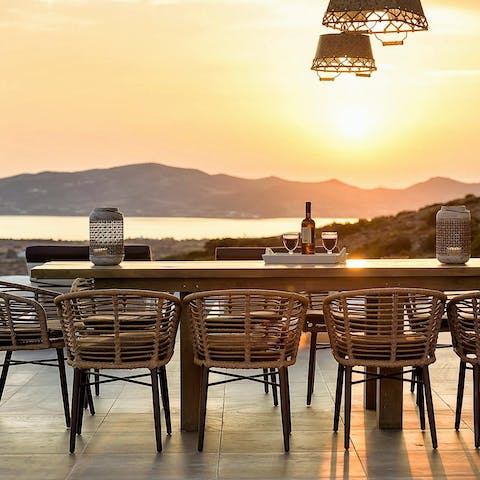 Watch the sun set over the ocean at the outdoor dining table