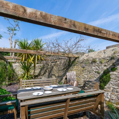 Dine alfresco under the sun at the rustic outdoor dining table