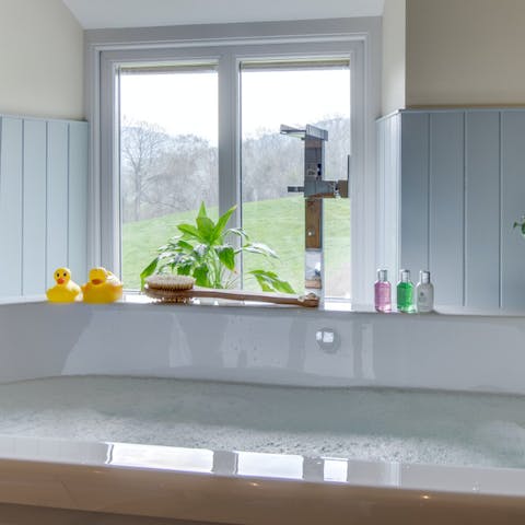 Relax in the bathtub, gazing out of the window at the lush views