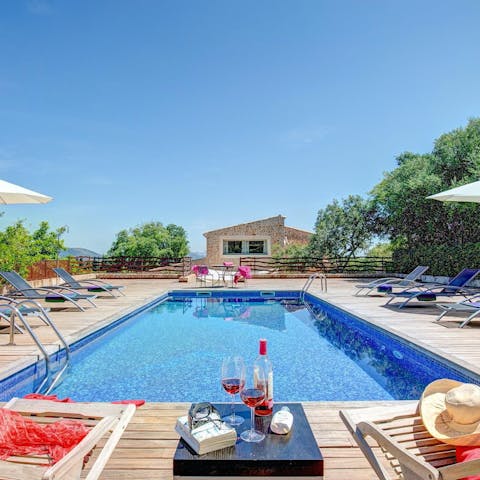 Savour a glass of sangría as you unwind by the pool