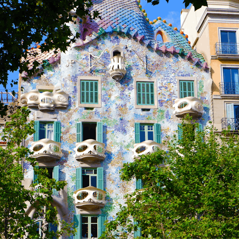 Admire the striking facade of Casa Batlló, a nineteen-minute walk from home