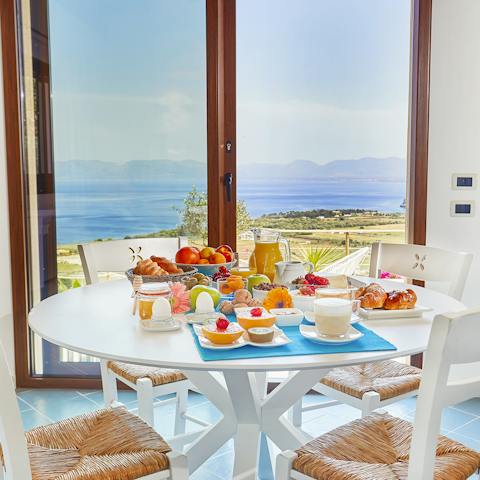 Set up for breakfast by the big windows with a view of the shimmering sea