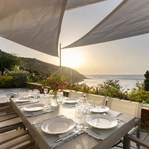 Dine with a sunset view of Andros' craggy coastline