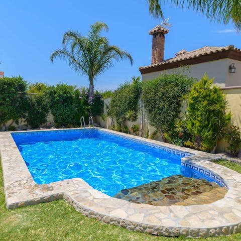 Cool off with a refreshing dip in your private, outdoor pool surrounded by lush greenery