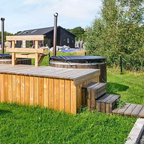 Relax in a the outdoor hot tub, with the lush greenery of the countryside surrounding you 