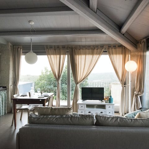 Lounge in the first floor living area and draw the curtains for panoramic views of the landscape outside