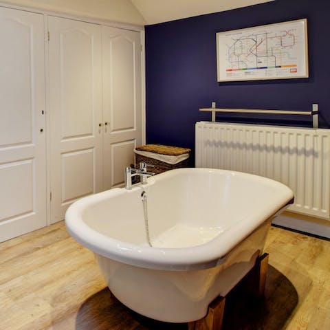 Relax after a long day with a soak in the lush roll-top bathtub 