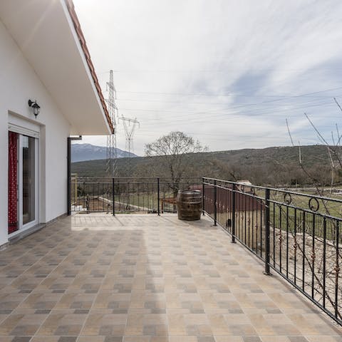 Sit out on the home's balcony and enjoy the tranquil view of green hillsides