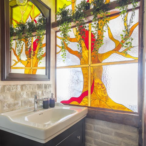 Be dazzled by the sun pouring through the bathroom's beautiful stained glass window