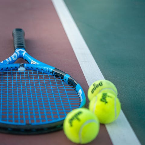 Enjoy a game of doubles on the tennis court behind the home
