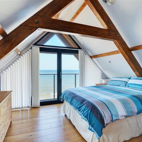 Wake up to coastal views out through the bedroom's glass doors