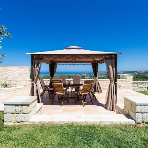 Dine in the shade of a curtained gazebo