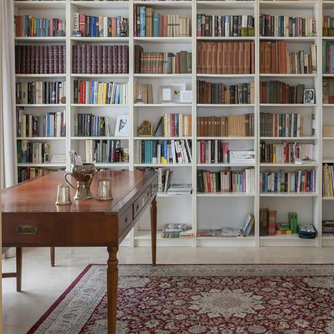 Peruse the bookshelves in the study in search of a new read