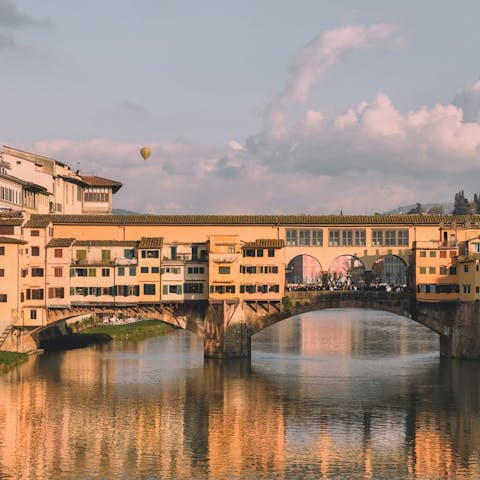 Savour the atmosphere while wandering across Ponte Vecchio