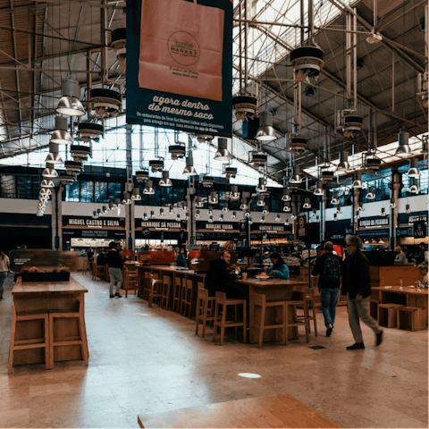 Enjoy a bite to eat in the Time Out Market, a twenty-minute tram ride away