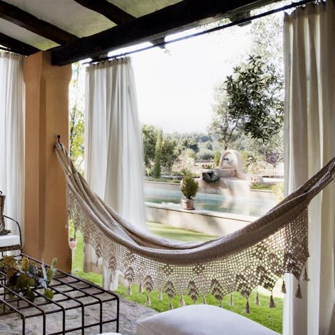 Relax in the poolside hammock, situated under a shady covered terrace