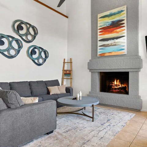 Gather around the contemporarily styled fireplace in the living room