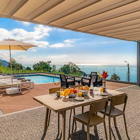 Enjoy a meal with views of the pool and the sea