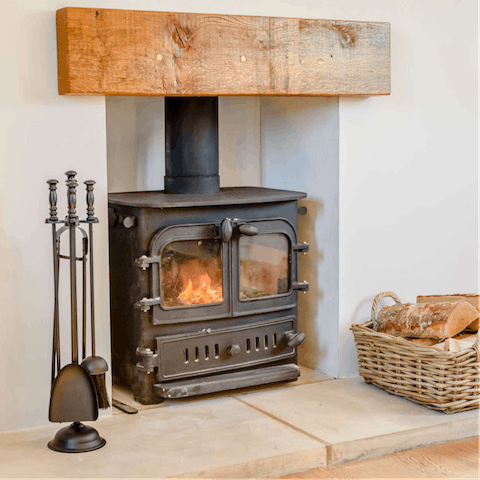 Warm up by the wood-burning stove in the cosy living room