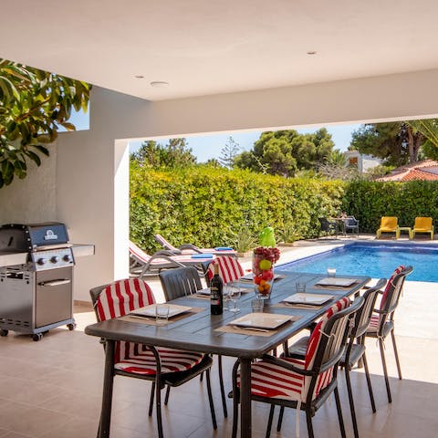 Gather your loved ones on the shaded terrace for a poolside barbecue